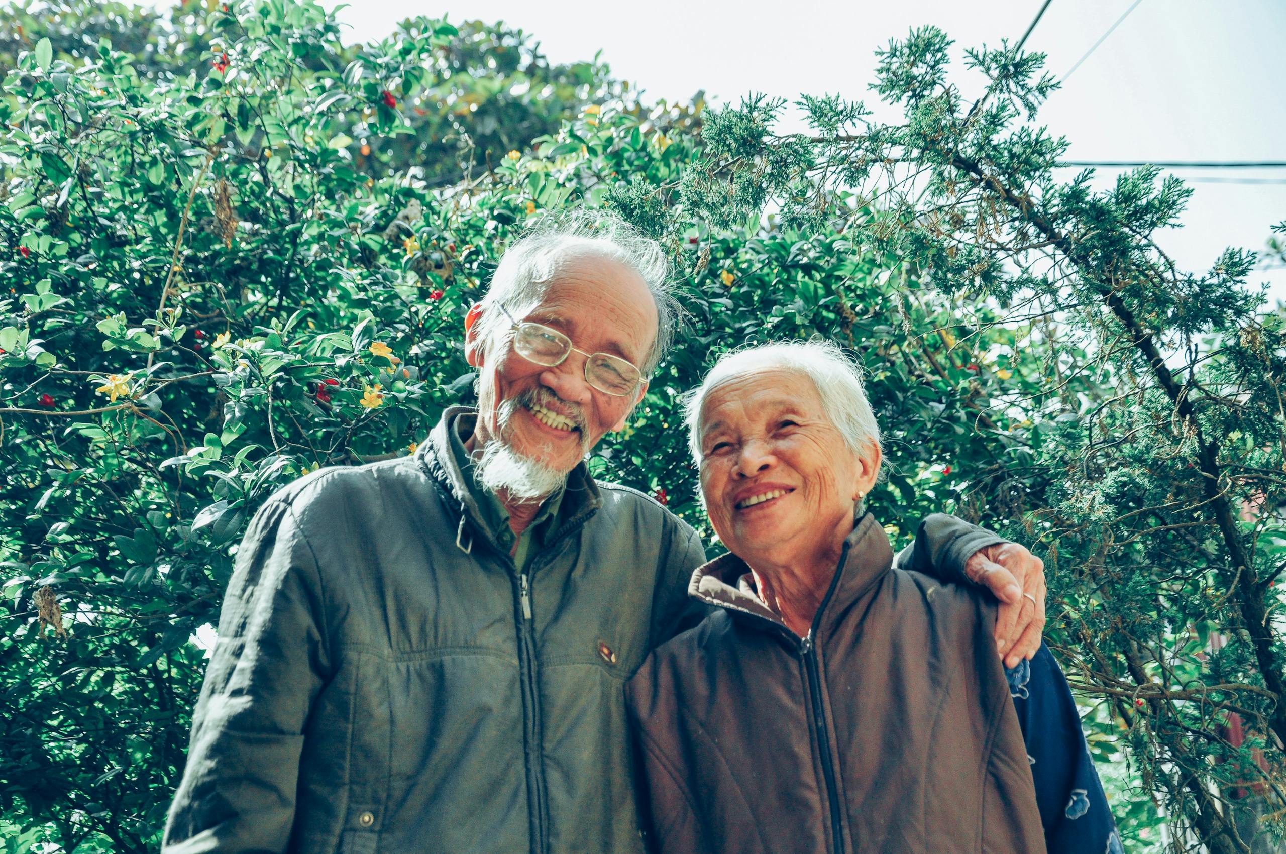 Senior couple enjoying a joyful moment together in a lush garden setting, exuding love and happiness. Retirement Planning